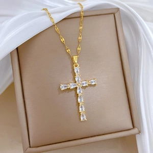 Detail of gold cross necklace with teardrop crystals in a beige velvet display box