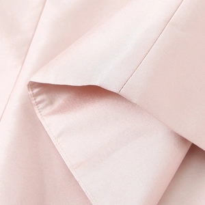 Robe dos nu en satin rose montrant la texture lisse du tissu et les coutures de qualité