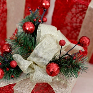 Macro detail of Christmas gift box bow with golden glitter, red berries and pine needles