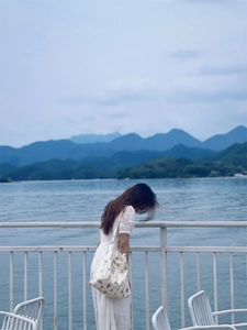 Floral print cotton canvas shoulder bag shown with white lace dress in scenic outdoor setting
