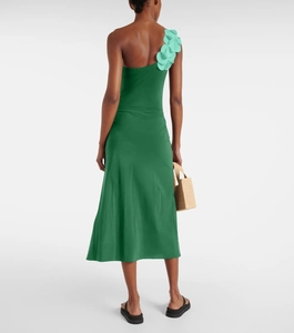 Detail of green satin one-shoulder dress with 3D floral accent and summer woven bag