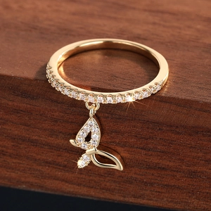 Macro shot of gold butterfly pendant ring with sparkling cubic zirconia on wood surface