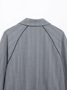 Detail of grey striped jacket back with dark blue piping at the shoulder seam