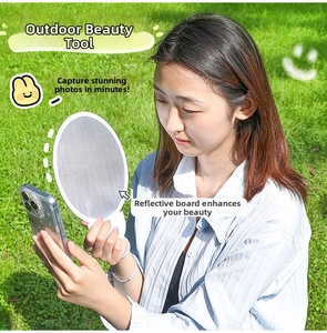 Outdoor-Selfie-Aufnahme mit einem tragbaren silbernen faltbaren Reflektor für Gesichtslicht