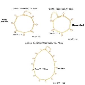 Detail of gold jewelry set with heart-shaped zircon pendants on a white background