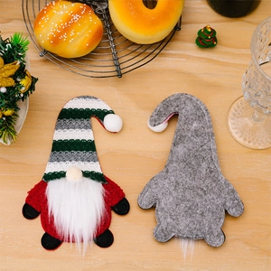 Close-up of gnome silverware holders on a wooden table for Christmas dining decoration