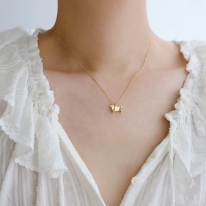 Detail of a gold-plated titanium steel necklace with a cute Corgi dog outline pendant