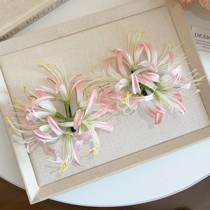 Detailed pair of pink Lycoris acrylic hair clips on a vintage beige tray display