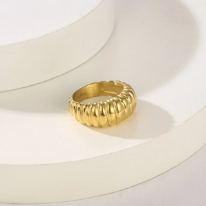 Dettaglio ravvicinato di un anello in acciaio inossidabile dorato con texture a costine