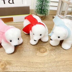 Set of three white flocked polar bear Christmas ornaments with colorful scarves on wood