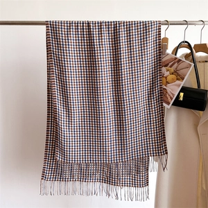 Detailed view of British brown and blue plaid cashmere scarf with soft tassel edges
