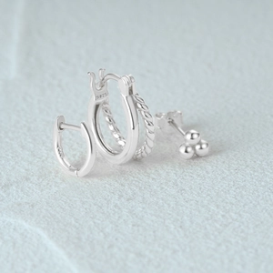 Detail of s925 sterling silver earring set showing S925 hallmark and polished textures