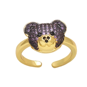 Detailed close-up of a golden teddy bear ring featuring sparkling purple crystals