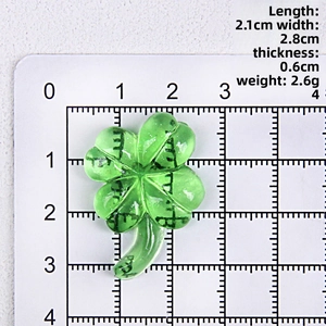Detailed size view of a 2.1x2.8cm green resin four-leaf clover pendant on scale board