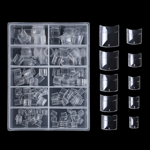 Macro detail of clear square French half-cover nail tips in a 10-compartment storage box