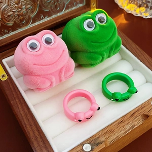 Cute pink and green frog rings with matching flocked jewelry boxes on display