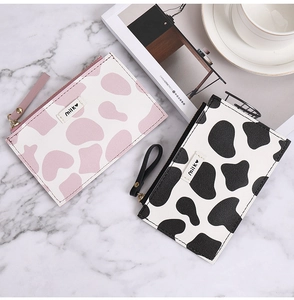 Close-up of cow print slim wallets with milk heart embroidery and secure metal zippers