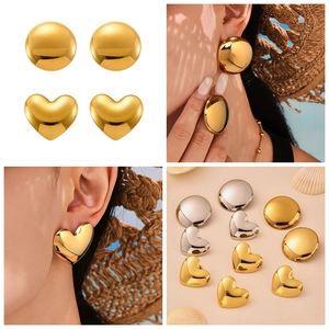 Close-up of heart-shaped and domed stud earrings with a high-shine metallic finish