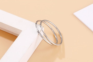 Macro shot of large polished 304 stainless steel hoop earrings on white geometric stands