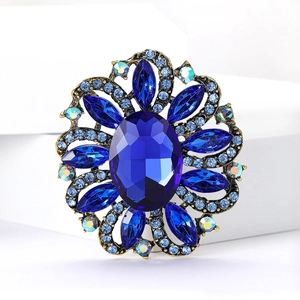 Macro shot of vintage bronze brooch with large oval blue stone and marquise crystals