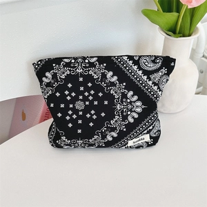 Detail view of large capacity black floral makeup bag with white paisley patterns