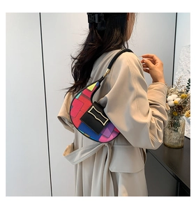Close-up of vibrant geometric color block handbag with a premium gold buckle detail