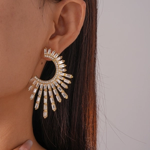 Detailed view of luxury C-shaped flower earrings with sparkling cubic zirconia on model