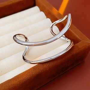Gros plan du bracelet ouvert double couche irrégulier en argent au fini métallique poli
