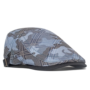 Detail of blue-grey camouflage newsboy cap featuring side metal adjustment buckle and brim