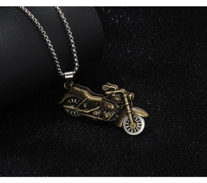 Close-up of a bronze vintage motorcycle pendant on a silver metal chain necklace