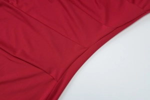 Détail d'une robe rouge en maille montrant la couture et la texture du tissu élastique