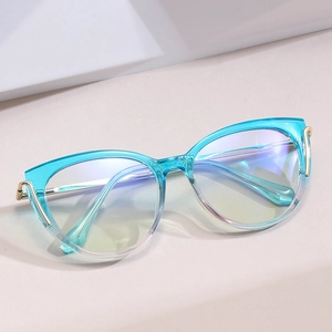Cat-eye blue gradient light blocking glasses with golden metal temple accents on grey background