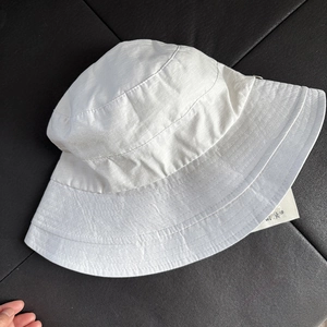 Detail view of white wide-brim bucket hat fabric texture and multi-row stitching design