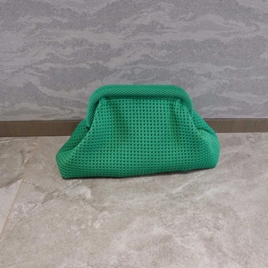 Detailed close-up of vibrant green knitted cloud clutch bag with woven mesh texture