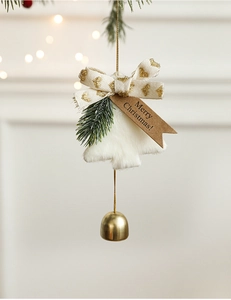 Detail of plush Christmas tree ornament with golden bell and Merry Christmas tag