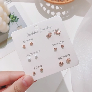 Detail of 6-pair rose gold stud earring set featuring pearls and stars on a weekly card