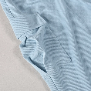 Detailed close-up of light blue waffle knit fabric and large side pocket stitching