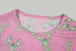 Detail of pink mesh fabric with green lobster print and round neck stitching craftsmanship