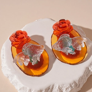 Vintage amber resin earrings with red rose and goldfish design on a textured stone base
