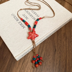 Detail of bohemian handmade wax rope necklace with starfish pendant and colorful beads
