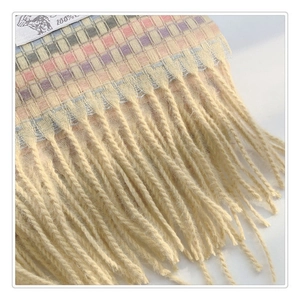 Détail des franges d'écharpe à motif pied-de-poule avec étiquette de qualité 100%