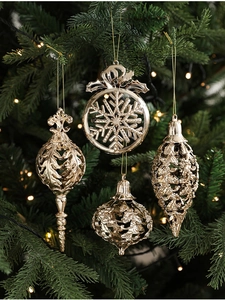 Dettaglio di quattro decorazioni dorate traforate per l'albero di Natale con fiocchi e renne