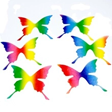 Vue détaillée de six épingles papillon arc-en-ciel disposées en cercle sur fond blanc