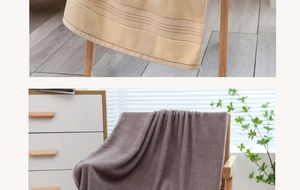 Detail showing the thick striped edges and soft cotton texture of the yellow towel