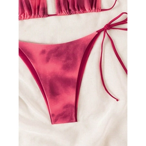Detail view of tie-dye gradient bikini bottom with side-tie strings on white fabric