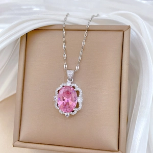 Detail of oval pink crystal pendant surrounded by small stones on silver chain