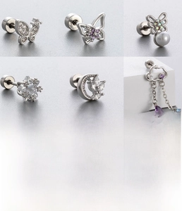 Macro detail of silver titanium steel earrings with zircon butterfly and cloud charms