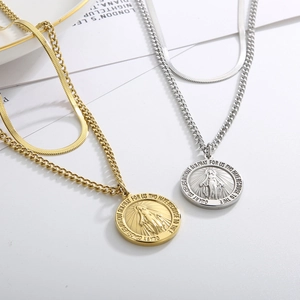 Detail of layered gold and silver necklaces with Virgin Mary medals and snake chains