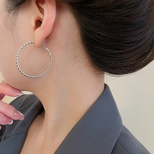 Silver twisted rope hoop earrings shown on model for size and minimalist style detail