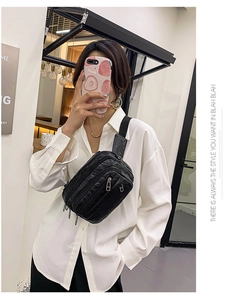 Gros plan d'un sac de poitrine noir motif crocodile porté par un mannequin en selfie
